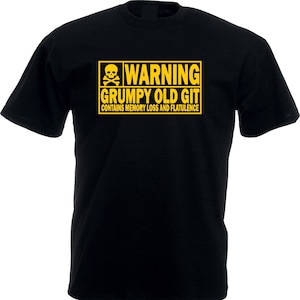 Può includere: T-shirt nero con un'etichetta di avvertimento gialla. L'etichetta presenta un teschio e ossa incrociate e il testo "WARNING GRUMPY OLD GIT CONTAINS MEMORY LOSS AND FLATULENCE."