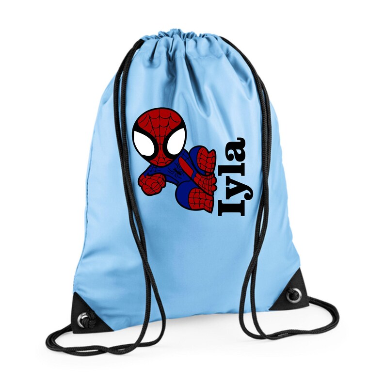 Puede incluir: Mochila con cord&oacute;n azul claro con un gr&aacute;fico de dibujos animados de Spider-Man en rojo, azul y negro. El nombre "Iyla" est&aacute; impreso en negro en el lado derecho. La bolsa tiene cordones negros y esquinas negras reforzadas.