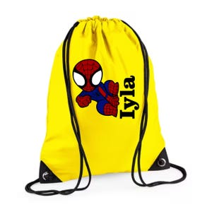 Puede incluir: Mochila con cord&oacute;n amarilla con un dibujo animado de Spider-Man en rojo, azul y negro. El nombre "Iyla" est&aacute; impreso en negro en el lado derecho. La bolsa tiene cordones negros y esquinas negras reforzadas.