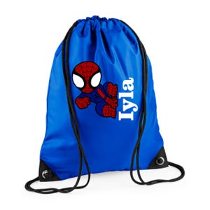 Puede incluir: Una mochila con cord&oacute;n azul real con un dise&ntilde;o de Spider-Man. El superh&eacute;roe est&aacute; representado en rojo y azul, con ojos blancos. El nombre "Iyla" est&aacute; impreso en blanco, verticalmente en el lado derecho de la bolsa. Cordones y ojales negros completan el dise&ntilde;o.