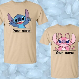 Peut inclure: Deux t-shirts beiges avec des personnages de dessins anim&eacute;s. L'un des t-shirts pr&eacute;sente un personnage bleu avec le texte "Your name" en dessous. L'autre t-shirt pr&eacute;sente un personnage rose avec le texte "Your name" en dessous.