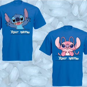 Peut inclure: Deux t-shirts bleus avec des personnages de dessins anim&eacute;s. L'un pr&eacute;sente un personnage bleu avec de grandes oreilles et le texte "Your name" en dessous. L'autre montre un personnage rose avec le m&ecirc;me texte.