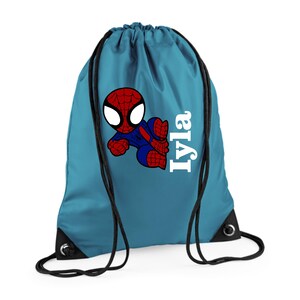 Puede incluir: Una mochila con cord&oacute;n de color turquesa con un dibujo animado de Spider-Man en rojo, azul y negro. El nombre "Iyla" est&aacute; impreso en blanco en el lado derecho. La bolsa tiene cordones y ojales negros.