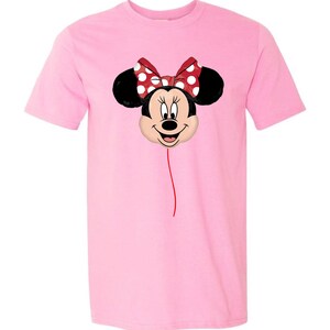 K&ouml;nnte beinhalten: Hellrosa T-Shirt mit einem Minnie Mouse Ballon-Design. Der Ballon hat eine rote Schleife mit wei&szlig;en Punkten, schwarze Ohren und ein l&auml;chelndes Gesicht. Eine d&uuml;nne rote Linie erstreckt sich vom Ballon.