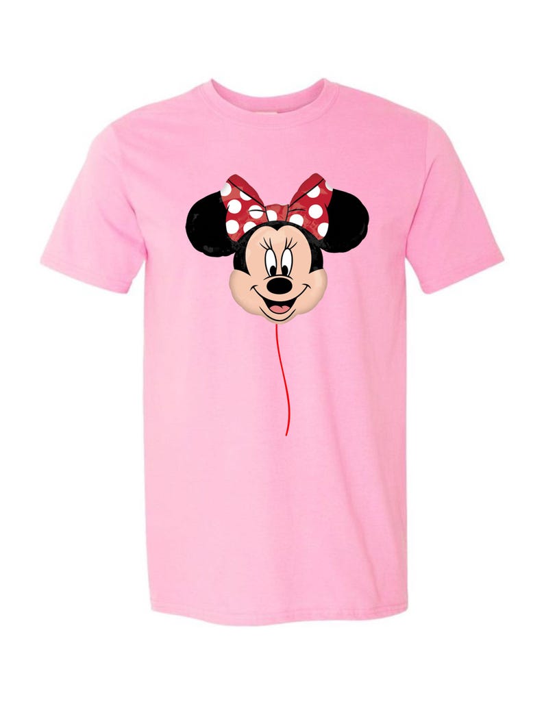 K&ouml;nnte beinhalten: Hellrosa T-Shirt mit einem Minnie Mouse Ballon-Design. Der Ballon hat eine rote Schleife mit wei&szlig;en Punkten, schwarze Ohren und ein l&auml;chelndes Gesicht. Eine d&uuml;nne rote Linie erstreckt sich vom Ballon.