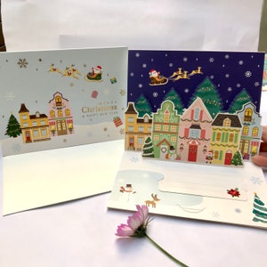 Handmade paper popup 3D glitter Christmas greeting card-Santa, Christmas tree reindeer sleigh house decoration snowman festival celebration.