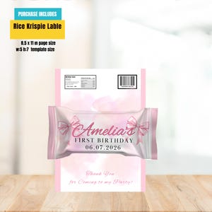 Puede incluir: Una etiqueta rosa de Rice Krispie con el texto "Amelia's FIRST BIRTHDAY 06.07.2026" y un mensaje de "Thank You". La etiqueta est&aacute; dise&ntilde;ada para un tama&ntilde;o de p&aacute;gina A4, con un tama&ntilde;o de plantilla de 12,7 cm de ancho y 17,8 cm de alto.