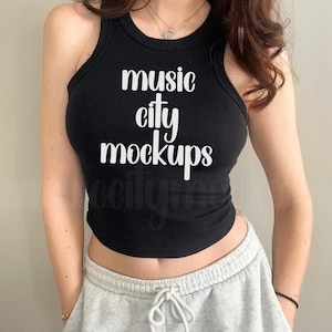 Puede incluir: Un top negro de tirantes con el texto "music city mockups" impreso en blanco.