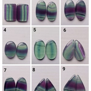 May include: Nine pairs of fluorite cabochons in various shapes and sizes. The cabochons are all green, purple, and white with a striated pattern. The cabochons are numbered 1 through 9.