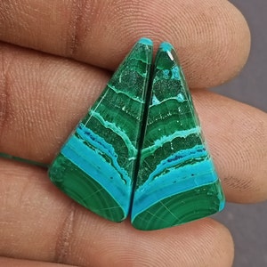 May include: A pair of green and blue gemstone cabochons with a triangular shape. The cabochons have a layered pattern with shades of green and blue.