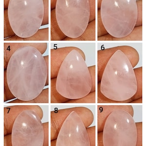 May include: Nine rose quartz cabochons in oval and teardrop shapes. The stones are a pale pink color and have a smooth, polished finish.
