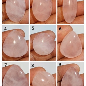 May include: Nine pink rose quartz cabochons in various shapes and sizes, including oval, teardrop, and round. The stones are translucent and have a light pink colour.
