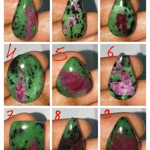 Puede incluir: Nueve piedras preciosas de rubí zoisita pulidas en varias formas, incluyendo lágrimas y óvalos. Las piedras presentan una mezcla de tonos verdes, negros y rosa-rojos. Cada piedra se sostiene en una mano.