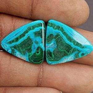 May include: A pair of green and blue malachite cabochons, cut into a triangular shape. The stones have a unique, swirling pattern.