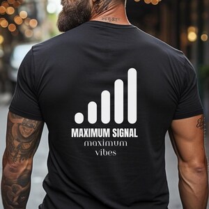Puede incluir: Camiseta negra con un gráfico blanco de un icono de barra de señal y el texto "MAXIMUM SIGNAL maximum vibes".