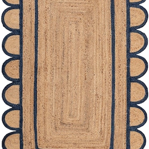 May include: A rectangular jute rug with a navy blue border and scalloped edges. The rug has a woven texture and a natural brown color.