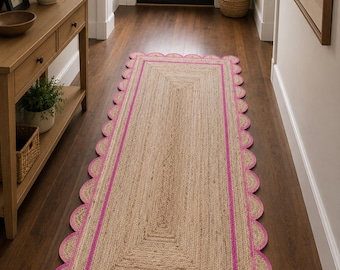 May include: A rectangular natural fiber runner rug featuring a woven tan texture with a bright pink border and a scalloped edge design. The rug is constructed with concentric rectangular patterns and a consistent pink trim along the entire perimeter.