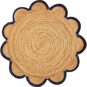 May include: A round, natural fiber rug with a scalloped edge. The rug is woven in a circular pattern and has a dark blue trim.