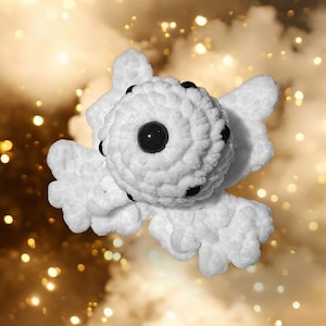 May include: White crocheted plush toy with black eyes and a round body. The toy is shaped like a cell with multiple arms.