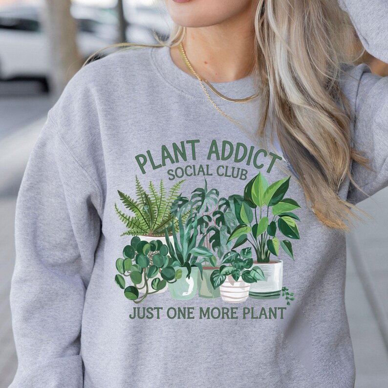 May include: Gray sweatshirt with a green plant graphic and the text "Plant Addict Social Club Just One More Plant".