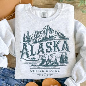 Alaska PNG svg Alaska State SVG, design par sublimation, croisière en Alaska png Sweat-shirt montagnes et arbres Design Alaskan Bear Wilderness PNG.