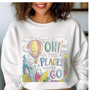 May include: White sweatshirt featuring a colourful graphic of a hot air balloon, clouds, and the text "Oh! The Places You'll Go."