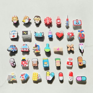 May include: A collection of 35 colorful medical themed shoe charms. The charms include a variety of medical symbols, such as a stethoscope, a heart, a bandage, and a pill bottle. There are also some cute cartoon characters, such as a nurse and a doctor.