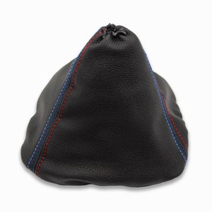 Könnte beinhalten: Schwarzer Lederschalthebelmanschette mit blauen und roten Nähten.