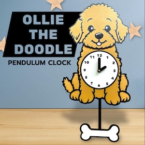 Puede incluir: Un reloj de péndulo caprichoso con forma de perro golden doodle. La esfera del reloj es blanca con números y manecillas negras. El reloj marca las 2:00. La base es un soporte negro con forma de hueso blanco. El texto "OLLIE THE DOODLE PENDULUM CLOCK" está arriba.