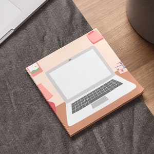 May include: A pink and beige illustrated sticker featuring a laptop computer with a white screen and a keyboard. The laptop is on a desk with a lamp and a picture frame.