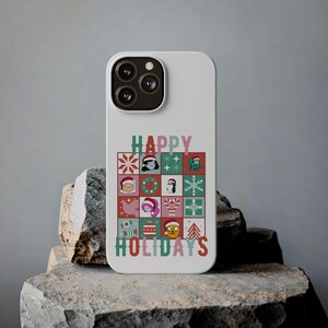Può includere: Una cover per smartphone bianca con una griglia di icone festive che include personaggi con cappelli da Babbo Natale, fiocchi di neve, bastoncini di zucchero e ornamenti. Il testo HAPPY HOLIDAYS è stampato in lettere verdi e rosse sulla griglia.