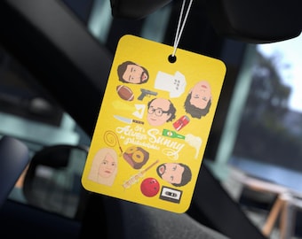 May include: A yellow car air freshener with a cartoon illustration of the characters from the TV show "It's Always Sunny in Philadelphia". The characters include Charlie, Mac, Dennis, Dee, and Frank. The air freshener has the show's logo and the text "It's Always Sunny in Philadelphia".