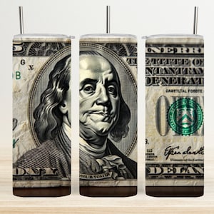 May include: A set of three stainless steel tumblers with a design featuring a close-up of a US dollar bill with Benjamin Franklin's portrait. The bill has the text "UNITED STATES OF AMERICA" and "ONE DOLLAR".
