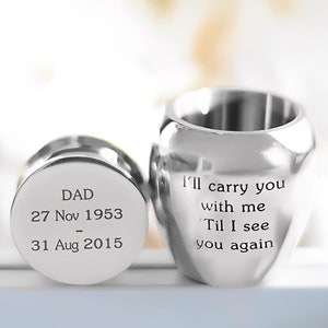 Puede incluir: Urna de recuerdo de plata con texto grabado: "DAD 27 Nov 1953 - 31 Aug 2015" en la tapa y "I'll carry you with me Til I see you again" en el cuerpo.