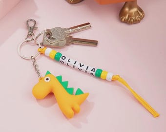 Personalisierte Dinosaurier Perle Schlüsselanhänger mit Name, Bunt Cartoon Dino Party Geschenk, Geburtstag oder Schulanfang Geschenk für Kinder, Jungen und Mädchen