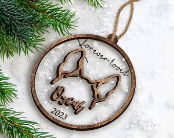 May include: A wooden Christmas ornament with a dog silhouette, the words "forever loved" and the name "Oscar" with the year 2023.