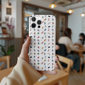 May include: White iPhone case with a pattern of hockey players and pucks. The case has a camera lens cutout and a white background.