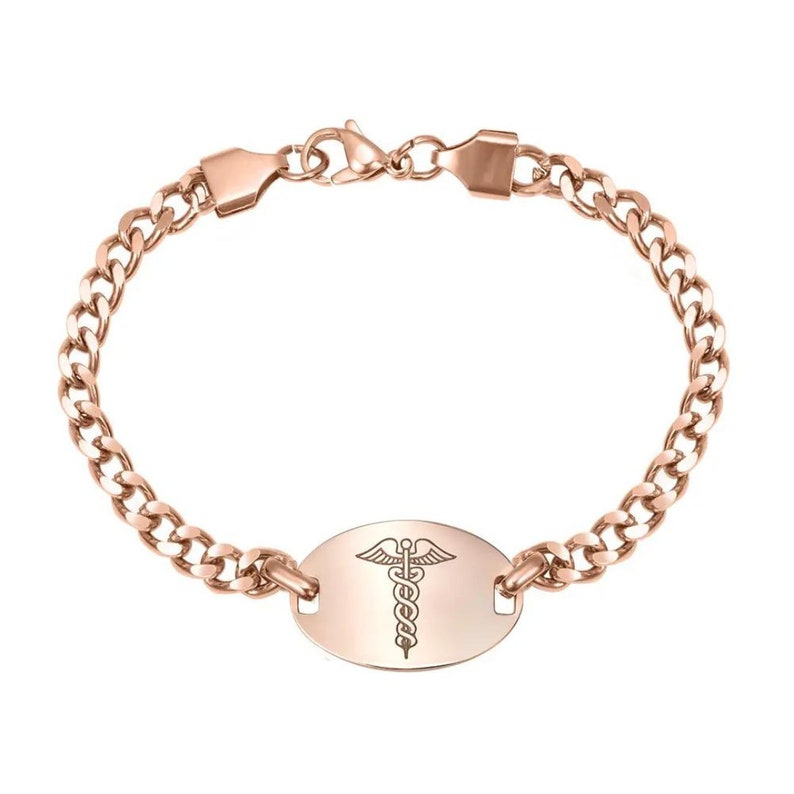 May include: Rose gold medical alert bracelet with a curb chain and an oval tag engraved with the medical symbol.