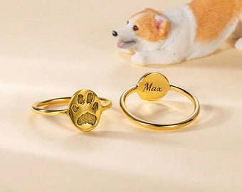 May include: Two gold rings, one with a paw print design and the other with the name "Max" engraved on it.