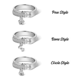 May include: Three silver rings with a dog collar design and a charm hanging from each. The charms are a paw print, a bone, and a circle. The text "Paw Style", "Bone Style", and "Circle Style" is displayed next to each ring.