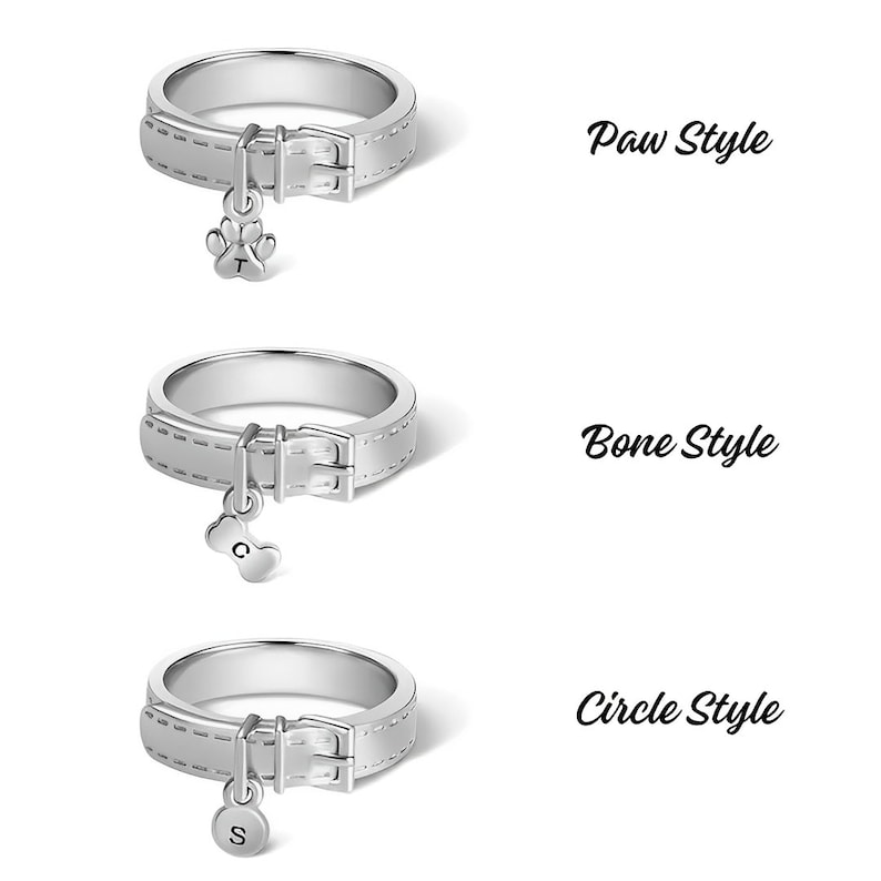 May include: Three silver rings with a dog collar design and a charm hanging from each. The charms are a paw print, a bone, and a circle. The text "Paw Style", "Bone Style", and "Circle Style" is displayed next to each ring.