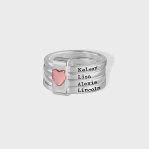 Pu&ograve; includere: Un anello d'argento con quattro fasce, ognuna incisa con un nome: Kelsey, Lisa, Alexis e Lincoln. Un cuore rosa sul lato. L'anello &egrave; un gioiello personalizzato.