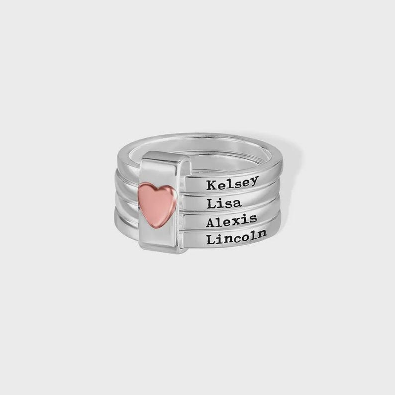 Pu&ograve; includere: Un anello d'argento con quattro fasce, ognuna incisa con un nome: Kelsey, Lisa, Alexis e Lincoln. Un cuore rosa sul lato. L'anello &egrave; un gioiello personalizzato.