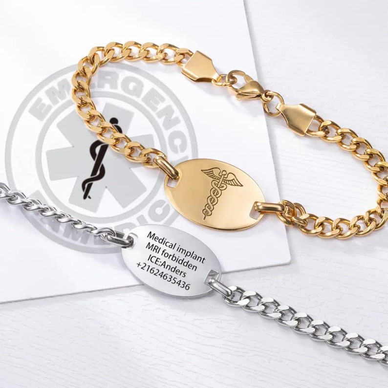 May include: Two medical alert bracelets, one gold and one silver. The gold bracelet has a medical symbol charm and the silver bracelet has an engraved tag that reads "Medical implant MRI forbidden ICE: Anders +21624635436".