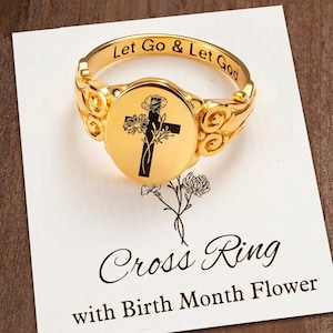 Puede incluir: Un anillo de sello de oro con un diseño de cruz y flor. El anillo tiene la inscripción "Let Go & Let God" en la banda. El anillo se muestra en una tarjeta blanca con el texto "Cross Ring with Birth Month Flower".