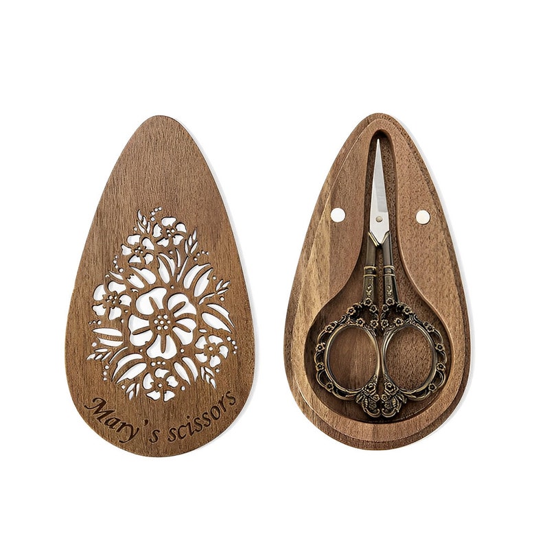 A pair of vintage-style scissors with stork-shaped handles. The scissors come with a wooden box that has a magnetic closure and a custom name or message engraved on it. It is a unique gift for seamstresses.