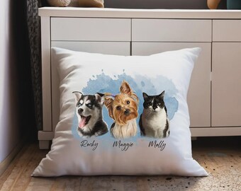 May include: White square pillow featuring watercolor portraits of a Husky, a Yorkshire Terrier, and a black and white cat. The pets' names, Rocky, Maggie, and Molly, are written below each portrait. A blue watercolor splash is behind the pets.