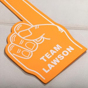 May include: Orange foam finger with the text "TEAM LAWSON" in white.