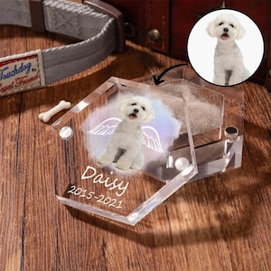Peut inclure: Un mémorial pour animaux de compagnie en acrylique transparent avec une photo d'un chien blanc avec des ailes d'ange, le nom "Daisy" et les années "2015-2021". Le mémorial hexagonal a un compartiment pour les poils d'animaux.