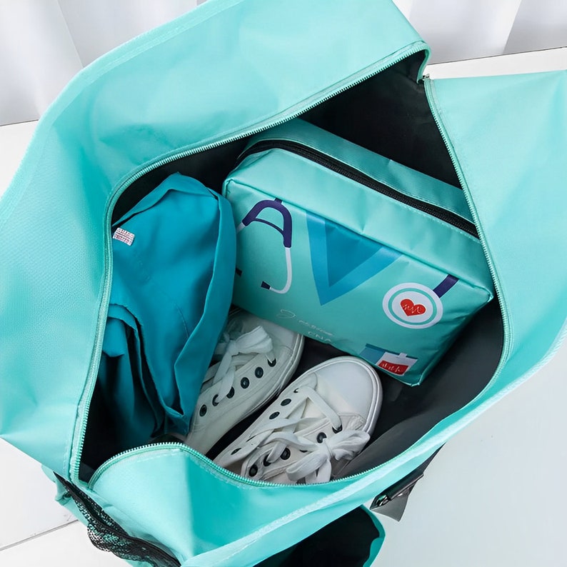 May include: A teal blue travel bag with a black zipper and a black mesh pocket. The bag is open and contains a teal blue pouch with a stethoscope and heart graphic, a teal blue shirt, and two white sneakers.